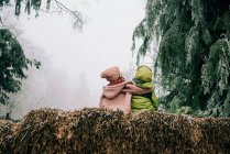 Zwei Freunde, die sich umarmten, saßen draußen zusammen und genossen die Winterszene — Stockfoto