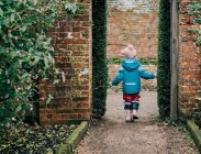 Niño caminando por un jardín de campo inglés en invierno - foto de stock