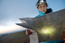 Туристка читает карту пешеходных маршрутов на Pen Y Fan в Уэльсе на рассвете — стоковое фото
