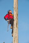 Homem ascendente pólo de madeira no exercício de treinamento de corda alta — Fotografia de Stock