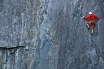 Woman climbing up steep rock face at Slate quarry in North Wales — Stock Photo