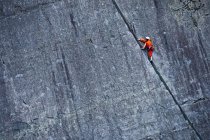 Woman climbing up steep rock face at Slate quarry in North Wales — Stock Photo