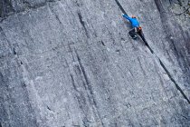 Mann klettert im Schieferbruch in Nordwales steile Felswand hinauf — Stockfoto