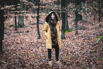 Femme forte naturelle avec manteau d'hiver et foulard se tient dans les bois dorés — Photo de stock