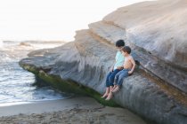Молодий чоловік і його син грають на березі моря — стокове фото