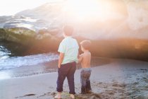 Pai e filho caminhando na praia — Fotografia de Stock