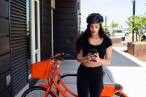 Jeune femme avec vélo et vélo — Photo de stock