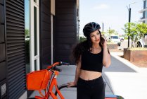 Giovane donna con bicicletta in città — Foto stock