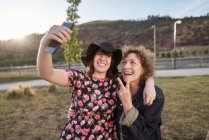 Une mère et une fille latines prennent une photo selfie avec leur téléphone portable — Photo de stock