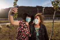 Una madre e una figlia latina scattano un selfie con un cellulare e — Foto stock