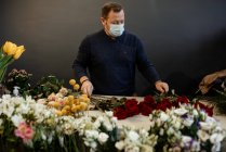 Florist making and selling bouquets of red roses for valentines day — Stock Photo