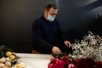 Floristería haciendo y vendiendo ramos de rosas rojas para el día de San Valentín - foto de stock