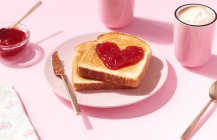 Toasts with heart shaped strawberry jam on it as a concept for love and Valentines Day — Stock Photo