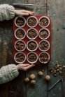 Des mains d'enfant tenant un plateau de muffins au chocolat non cuits sur le point de cuire — Photo de stock