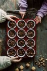 Mani bambino in possesso di un vassoio di muffin al cioccolato crudo in procinto di cuocere — Foto stock
