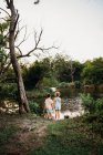 Симпатичные мальчик и девочка у озера — стоковое фото