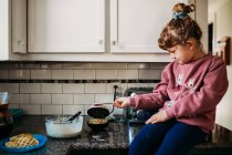 Милая маленькая девочка готовит — стоковое фото