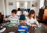 Cute boy and girl drawing at home — Stock Photo