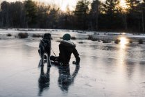 Netter Junge auf gefrorenem See Schlittschuhlaufen — Stockfoto