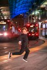 Boy dancing at a Downtown train station at nigh time. — Stock Photo