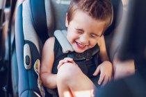 Niño en edad preescolar sentado en el asiento de coche dentro de un coche. - foto de stock