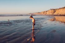 Giovane ragazzo al tramonto sulla spiaggia — Foto stock
