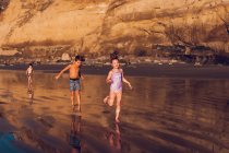 Niños lindos divirtiéndose en la playa - foto de stock