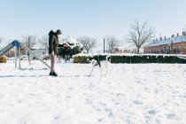 Man training his dog in the snow and play with a ball — Stock Photo