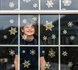 Petit enfant avec des décorations de Noël dans la chambre — Photo de stock