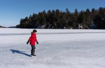 Молодий хлопчик катається на крижаному озері в зимовий день в Канаді.. — стокове фото