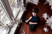 Bambino con decorazioni natalizie in camera — Foto stock