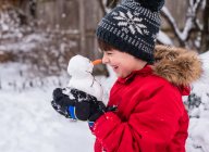 El niño con muñeco de nieve en un bosque cubierto de nieve - foto de stock