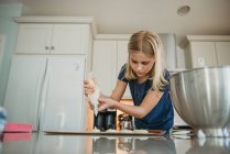 Молодая девушка печет макароны на кухне — стоковое фото