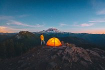 Ansicht einer Frau und eines Zeltes vor dem Hintergrund der Berge und des Mondes — Stockfoto