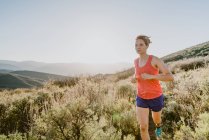 Sentiero donna bionda atletica corre in montagna all'ora d'oro — Foto stock