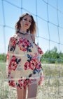 Primo piano di una giovane donna che indossa un abito estivo con fiori e earrin — Foto stock