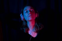 Porträt einer Frau mit Kopfhörern mit roten und blauen Neonlichtern — Stockfoto