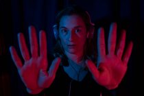 Retrato de mulher com fones de ouvido com luzes de néon vermelho e azul. — Fotografia de Stock