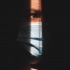 Mann mit Maske im Schatten zeigt das braune Auge — Stockfoto