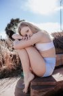 Teen girl sitzt draußen an einem sonnigen Tag im Badeanzug — Stockfoto