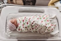 Bambino appena nato in culla avvolto in coperta ospedaliera — Foto stock