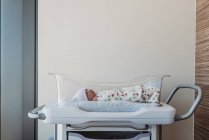Новонароджений хлопчик у бассеті, загорнутий у лікарняну ковдру — стокове фото
