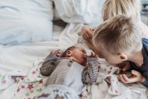 Menino recém-nascido conhecendo irmãos grandes pela primeira vez no hospital — Fotografia de Stock