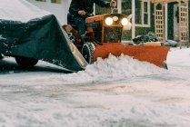 Mann auf Oldtimer restauriertem Traktor pflügt Schnee im Sturm — Stockfoto