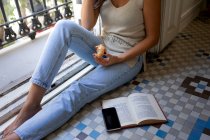 Молода жінка сидить на підлозі і читає книгу — стокове фото