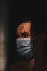 Man with mask in the shadows, covid protection — Stock Photo