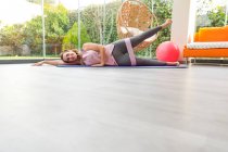 Jovem fazendo ioga no tapete no ginásio — Fotografia de Stock