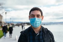 Портрет молодого чоловіка на вулиці в масці для обличчя — стокове фото