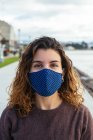 Giovane donna per strada indossando una maschera facciale — Foto stock