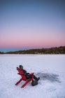 Garçon pêche tandis que assis sur la neige — Photo de stock